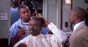 Movie still from “Barbershop 2: Back in Business” (2004), directed by Kevin Rodney Sullivan – A man getting his hair combed by another man; Close Up shot, Over the shoulder angle