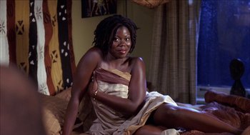 Movie still from “Barbershop 2: Back in Business” (2004), directed by Kevin Rodney Sullivan – A woman sitting on top of a bed in a room; Medium shot, High angle