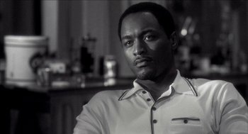 Movie still from “Barbershop 2: Back in Business” (2004), directed by Kevin Rodney Sullivan – A black and white photo of a man looking at the camera; Close Up shot, Low angle