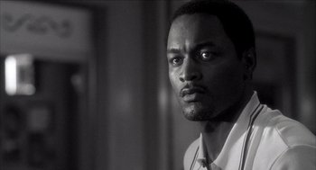 Movie still from “Barbershop 2: Back in Business” (2004), directed by Kevin Rodney Sullivan – A black and white photo of a man looking at the camera; Close Up shot, Low angle