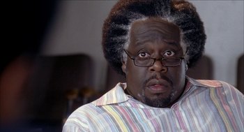 Movie still from “Barbershop 2: Back in Business” (2004), directed by Kevin Rodney Sullivan – A person wearing glasses and a striped shirt; Close Up shot, Over the shoulder angle
