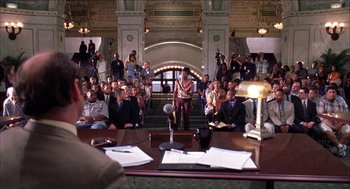 Movie still from “Barbershop 2: Back in Business” (2004), directed by Kevin Rodney Sullivan – A group of people sitting in a room with microphones; Wide shot, Over the shoulder angle
