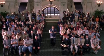 Movie still from “Barbershop 2: Back in Business” (2004), directed by Kevin Rodney Sullivan – A group of people sitting in a room with microphones; Extreme Wide shot, High angle