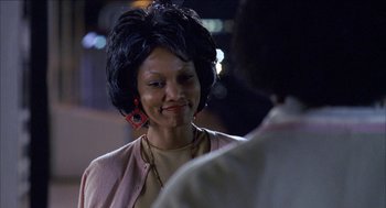 Movie still from “Barbershop 2: Back in Business” (2004), directed by Kevin Rodney Sullivan – A woman wearing a pink jacket and red earrings talking to a man; Close Up shot, Over the shoulder angle