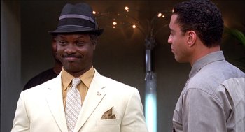 Movie still from “Barbershop 2: Back in Business” (2004), directed by Kevin Rodney Sullivan – A man in a suit and hat standing next to another man in a suit; Close Up shot, Over the shoulder angle