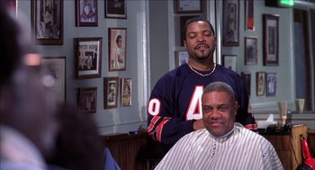 Movie still from “Barbershop 2: Back in Business” (2004), directed by Kevin Rodney Sullivan – A man getting his hair cut by another man; Medium shot, Over the shoulder angle