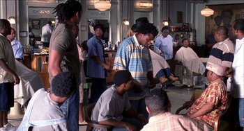Movie still from “Barbershop 2: Back in Business” (2004), directed by Kevin Rodney Sullivan – A group of people standing in a room; Medium shot, Over the shoulder angle