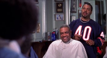 Movie still from “Barbershop 2: Back in Business” (2004), directed by Kevin Rodney Sullivan – A man getting his hair cut in a barber shop; Medium shot, Over the shoulder angle