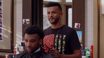 Movie still from “Barbershop: The Next Cut” (2016), directed by Malcolm D. Lee – A man getting his hair cut by another man; Close Up shot, Over the shoulder angle