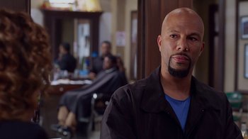 Movie still from “Barbershop: The Next Cut” (2016), directed by Malcolm D. Lee – A bald man with a beard is posing for a picture; Close Up shot, Over the shoulder angle