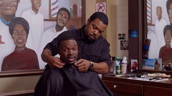 Movie still from “Barbershop: The Next Cut” (2016), directed by Malcolm D. Lee – A man getting his hair cut by a barber; Medium shot, Over the shoulder angle