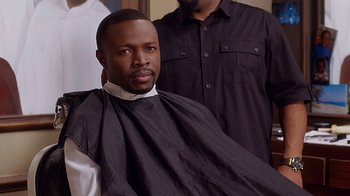 Movie still from “Barbershop: The Next Cut” (2016), directed by Malcolm D. Lee – A man sitting in front of another man in a barber chair; Close Up shot, Over the shoulder angle