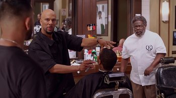 Movie still from “Barbershop: The Next Cut” (2016), directed by Malcolm D. Lee – A man getting his hair cut in a barber shop; Medium shot, Over the shoulder angle