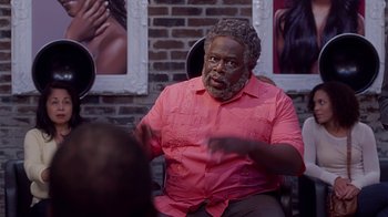 Movie still from “Barbershop: The Next Cut” (2016), directed by Malcolm D. Lee – An older black man wearing a pink shirt talking to someone; Close Up shot, Over the shoulder angle