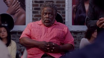 Movie still from “Barbershop: The Next Cut” (2016), directed by Malcolm D. Lee – An older black man wearing a pink shirt; Close Up shot, Over the shoulder angle