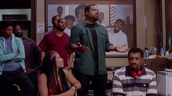 Movie still from “Barbershop: The Next Cut” (2016), directed by Malcolm D. Lee – A group of people in a room talking to each other; Medium shot, Over the shoulder angle
