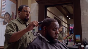 Movie still from “Barbershop: The Next Cut” (2016), directed by Malcolm D. Lee – A man getting his hair cut at a barber shop; Close Up shot, Over the shoulder angle