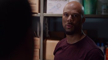 Movie still from “Barbershop: The Next Cut” (2016), directed by Malcolm D. Lee – A bald man with a beard is looking at the camera; Close Up shot, Over the shoulder angle