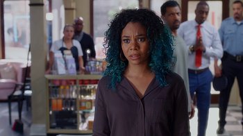 Movie still from “Barbershop: The Next Cut” (2016), directed by Malcolm D. Lee – A woman with blue hair standing in front of a group of people; Close Up shot, Over the shoulder angle