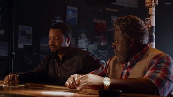 Movie still from “Barbershop: The Next Cut” (2016), directed by Malcolm D. Lee – Two men sitting at a table at a bar; Medium shot, Over the shoulder angle
