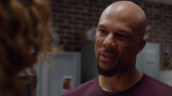 Movie still from “Barbershop: The Next Cut” (2016), directed by Malcolm D. Lee – A bald man with a beard is standing in a room; Close Up shot, Over the shoulder angle