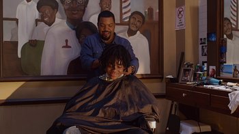 Movie still from “Barbershop: The Next Cut” (2016), directed by Malcolm D. Lee – A man getting his hair cut by another man; Medium shot, Over the shoulder angle
