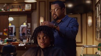 Movie still from “Barbershop: The Next Cut” (2016), directed by Malcolm D. Lee – A man cutting a child's hair in front of a mirror; Close Up shot, Over the shoulder angle