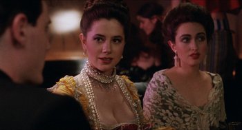 Movie still from “Barcelona” (1994), directed by Whit Stillman – A woman in a yellow and red dress with pearls in her hair; Close Up shot, Over the shoulder angle