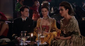 Movie still from “Barcelona” (1994), directed by Whit Stillman – A group of people sitting at a table with drinks; Medium shot, Over the shoulder angle