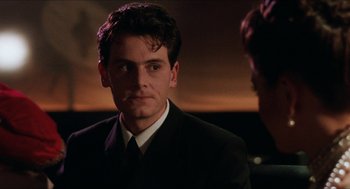 Movie still from “Barcelona” (1994), directed by Whit Stillman – A man in a suit and tie looking at the camera; Close Up shot, Over the shoulder angle