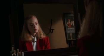 Movie still from “Barcelona” (1994), directed by Whit Stillman – A woman in a red jacket looking in a mirror; Close Up shot, Over the shoulder angle