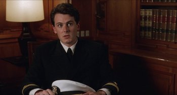 Movie still from “Barcelona” (1994), directed by Whit Stillman – A man in a uniform sitting in front of a table; Close Up shot, High angle