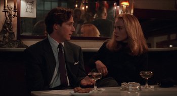 Movie still from “Barcelona” (1994), directed by Whit Stillman – A man and a woman sitting at a table in front of a glass of wine; Medium shot, Low angle