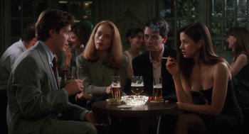 Movie still from “Barcelona” (1994), directed by Whit Stillman – A group of people sitting around a table with drinks; Medium shot, Over the shoulder angle