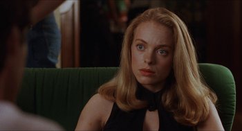 Movie still from “Barcelona” (1994), directed by Whit Stillman – A person sitting on a chair; Close Up shot, Over the shoulder angle