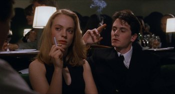 Movie still from “Barcelona” (1994), directed by Whit Stillman – A man and a woman are smoking a cigarette together; Close Up shot, Low angle