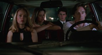 Movie still from “Barcelona” (1994), directed by Whit Stillman – A group of people sitting in the back of a car at night; Medium shot, Low angle