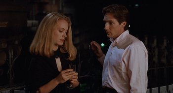 Movie still from “Barcelona” (1994), directed by Whit Stillman – A man and a woman standing next to each other holding wine glasses; Medium shot, Low angle