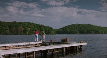 Movie still from “Barcelona” (1994), directed by Whit Stillman – Two men standing on a pier fishing for fish; Extreme Wide shot, Low angle
