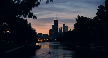 Movie still from “Barcelona” (1994), directed by Whit Stillman – A view of a city from across the river at dusk; Extreme Wide shot, High angle