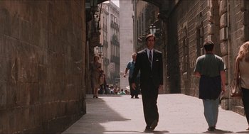 Movie still from “Barcelona” (1994), directed by Whit Stillman – A man in a suit walking down a street; Wide shot, Low angle
