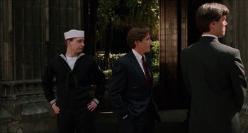 Movie still from “Barcelona” (1994), directed by Whit Stillman – Two men in suits and ties standing next to each other; Medium shot, Over the shoulder angle