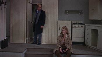 Movie still from “Barefoot in the Park” (1967), directed by Gene Saks – A man and a woman sitting on steps in front of an oven; Wide shot, High angle