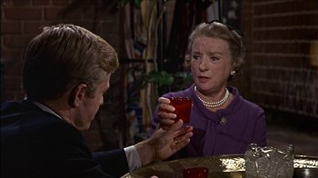 Movie still from “Barefoot in the Park” (1967), directed by Gene Saks – An older woman holding a red cup in front of a younger man; Medium shot, Over the shoulder angle