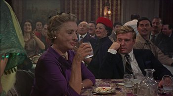 Movie still from “Barefoot in the Park” (1967), directed by Gene Saks – An older woman holding a glass of wine at a party; Medium shot, Over the shoulder angle