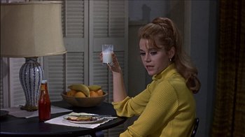 Movie still from “Barefoot in the Park” (1967), directed by Gene Saks – A woman sitting at a table holding a glass of milk; Medium shot, Over the shoulder angle