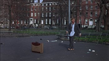 Movie still from “Barefoot in the Park” (1967), directed by Gene Saks – A man standing in a parking lot next to a suitcase; Wide shot, High angle