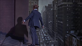 Movie still from “Barefoot in the Park” (1967), directed by Gene Saks – A man standing on a ledge looking at a busy street; Wide shot, Low angle