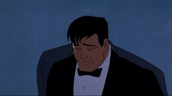 Movie still from “Batman: Mask of the Phantasm” (1993), directed by Kevin Altieri – A man in a tuxedo sitting in front of a blue background; Medium shot, Low angle
