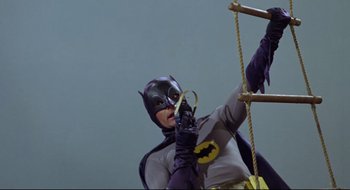 Movie still from “Batman: The Movie” (1966), directed by Leslie H. Martinson – A woman dressed as batman is climbing a rope ladder; Medium shot, Low angle